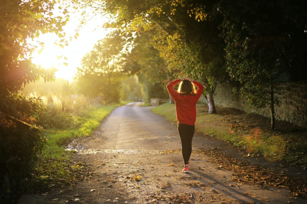 Woman in jogging clothes with sunlight peaking through the frame