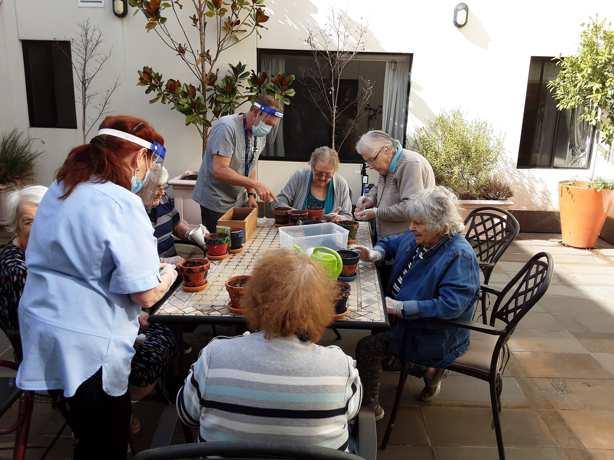 Aged care providers interacting with elderly patients on a group activity