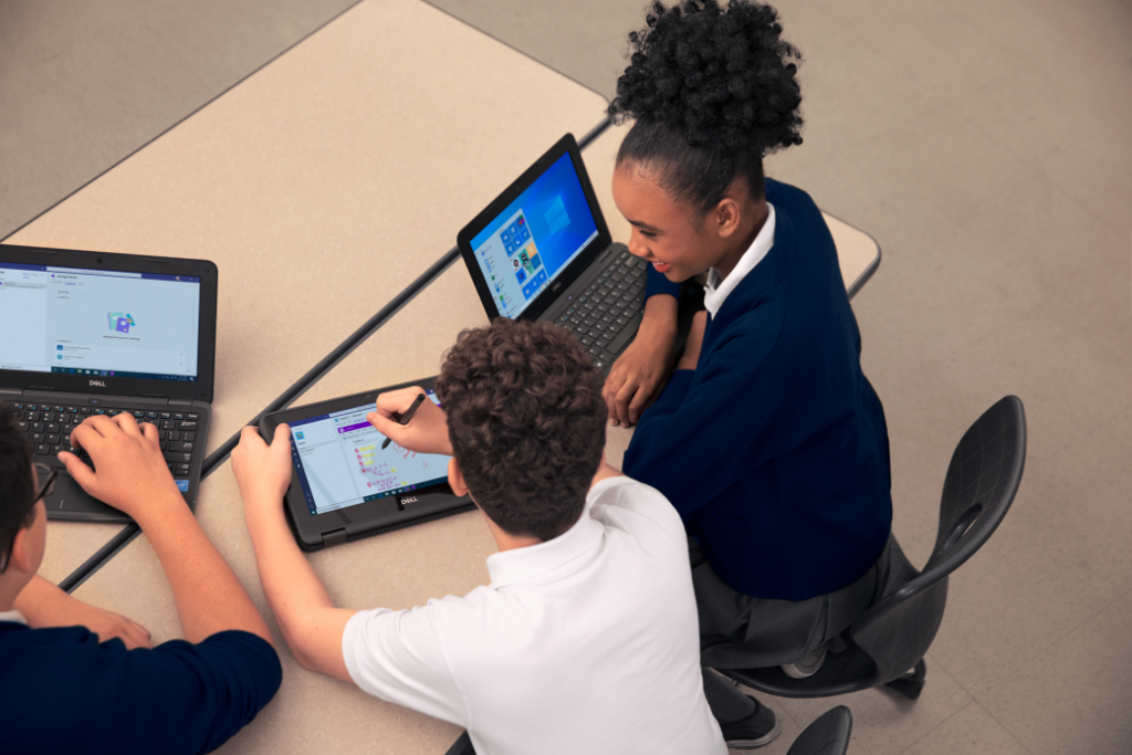 Three uniformed K-12 students using Dell Latitude 3190 and Dell Latitude 3190 2-in-1 devices in the classroom.
