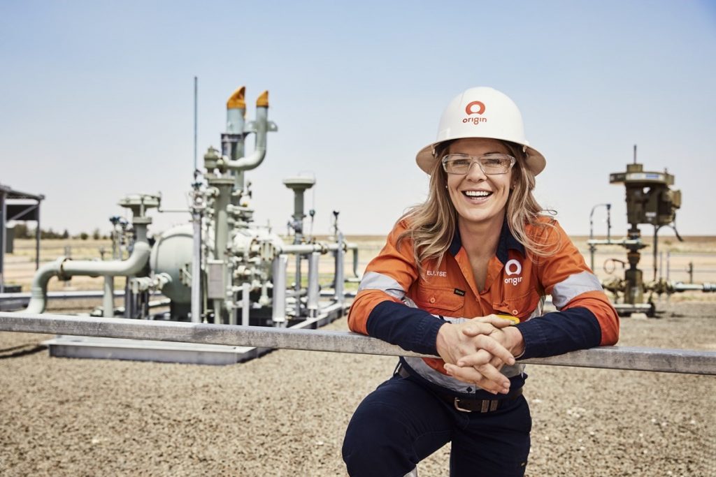 Female employee standing infront of an energy facility