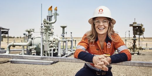 Female employee standing infront of an energy facility