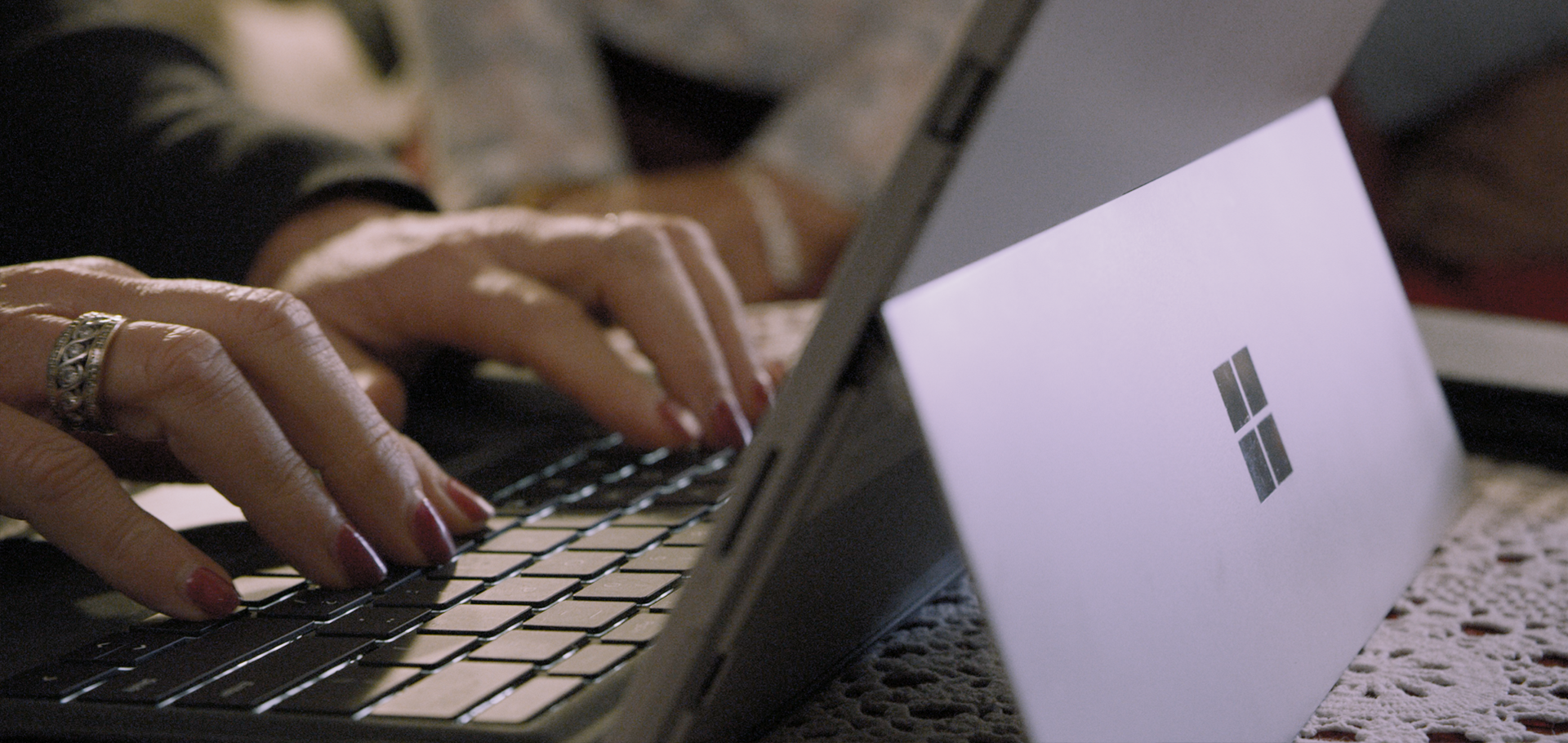 Close up of a person typing on a Surface laptop