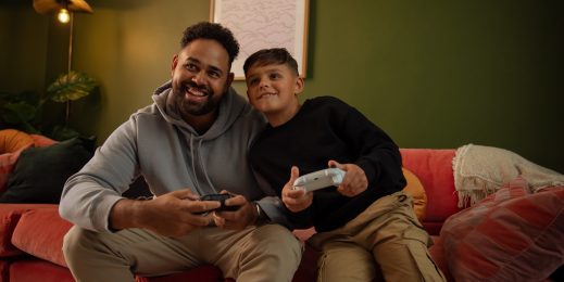 Adult male and young boy playing with Xbox controllers