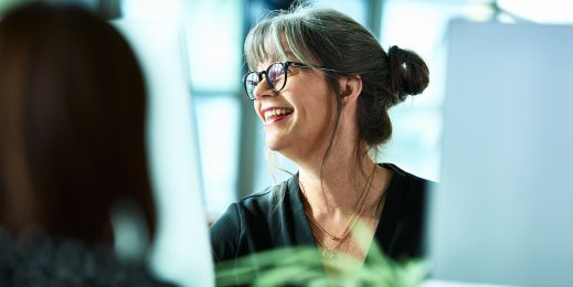 Candid portrait of mature businesswoman in glasses laughing