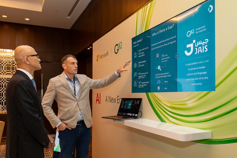 A man demonstrating his application to Microsoft Chairman and CEO Satya Nadella