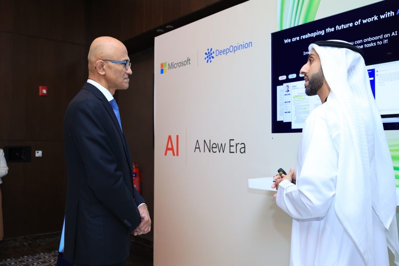 Microsoft Chairman and CEO Satya Nadella interacts with a man at an event booth