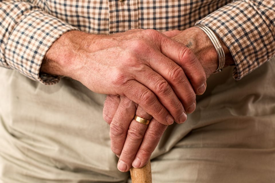 An old man's hands on a walking stick