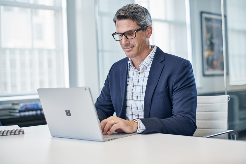 man using Surface Book in office