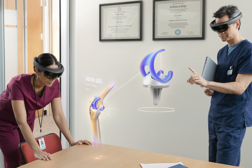 Two doctors using HoloLens to look at hologram of knee joint