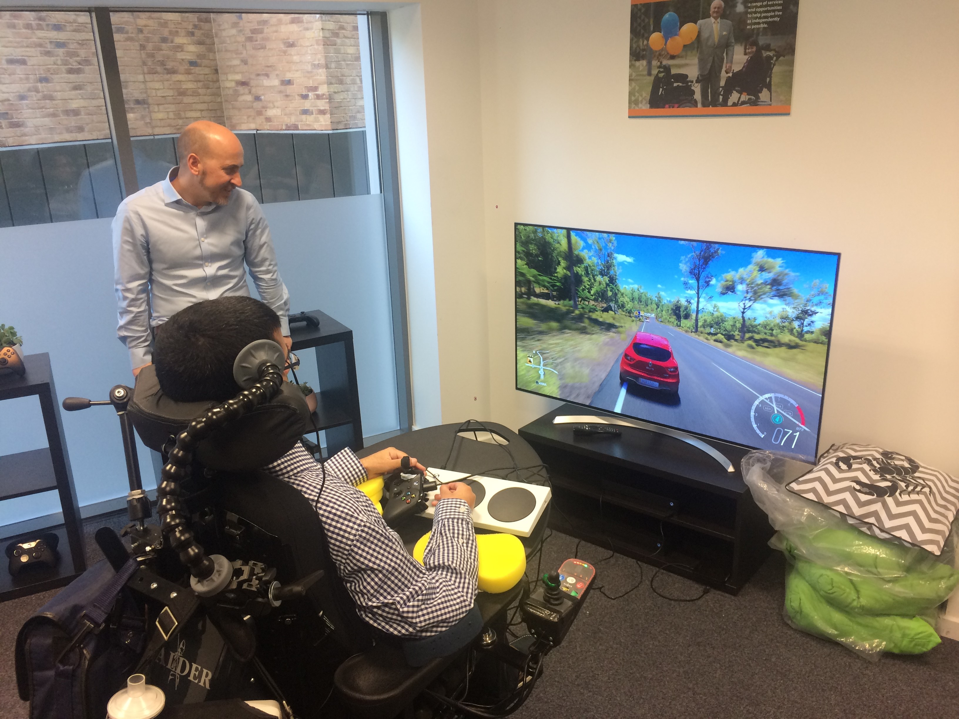 Hector Minto, from Microsoft, watches Vivek Gohill play Forza Horizon 3 using the George Dowell plays FIFA with the Xbox Adaptive Controller