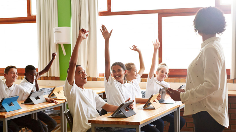 Kids with hands up in classroom
