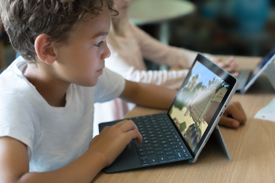 Boy playing Minecraft on Surface Go in classroom