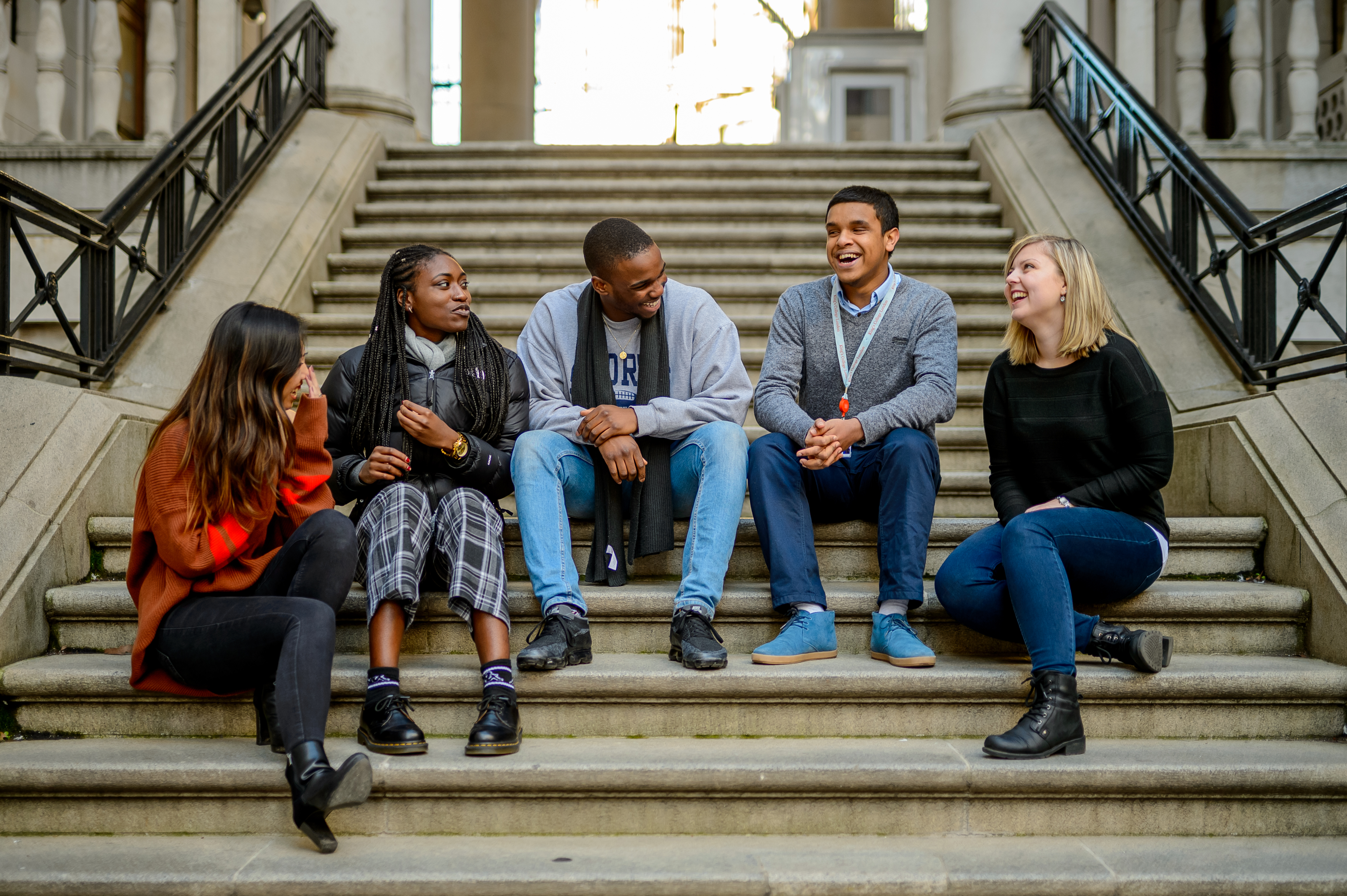 Five King's College London students sitting on steps