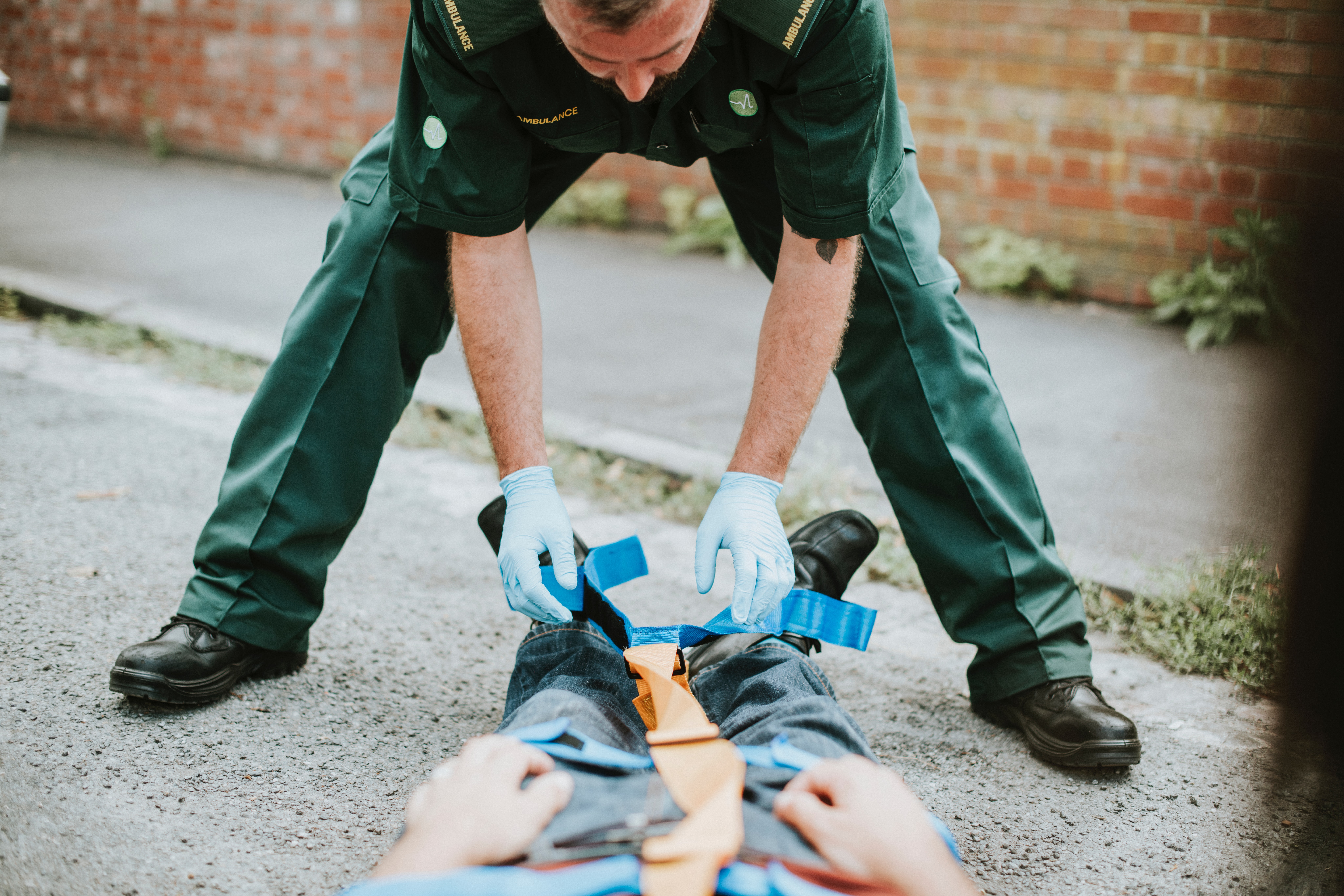 Paramedic helping patient on a street