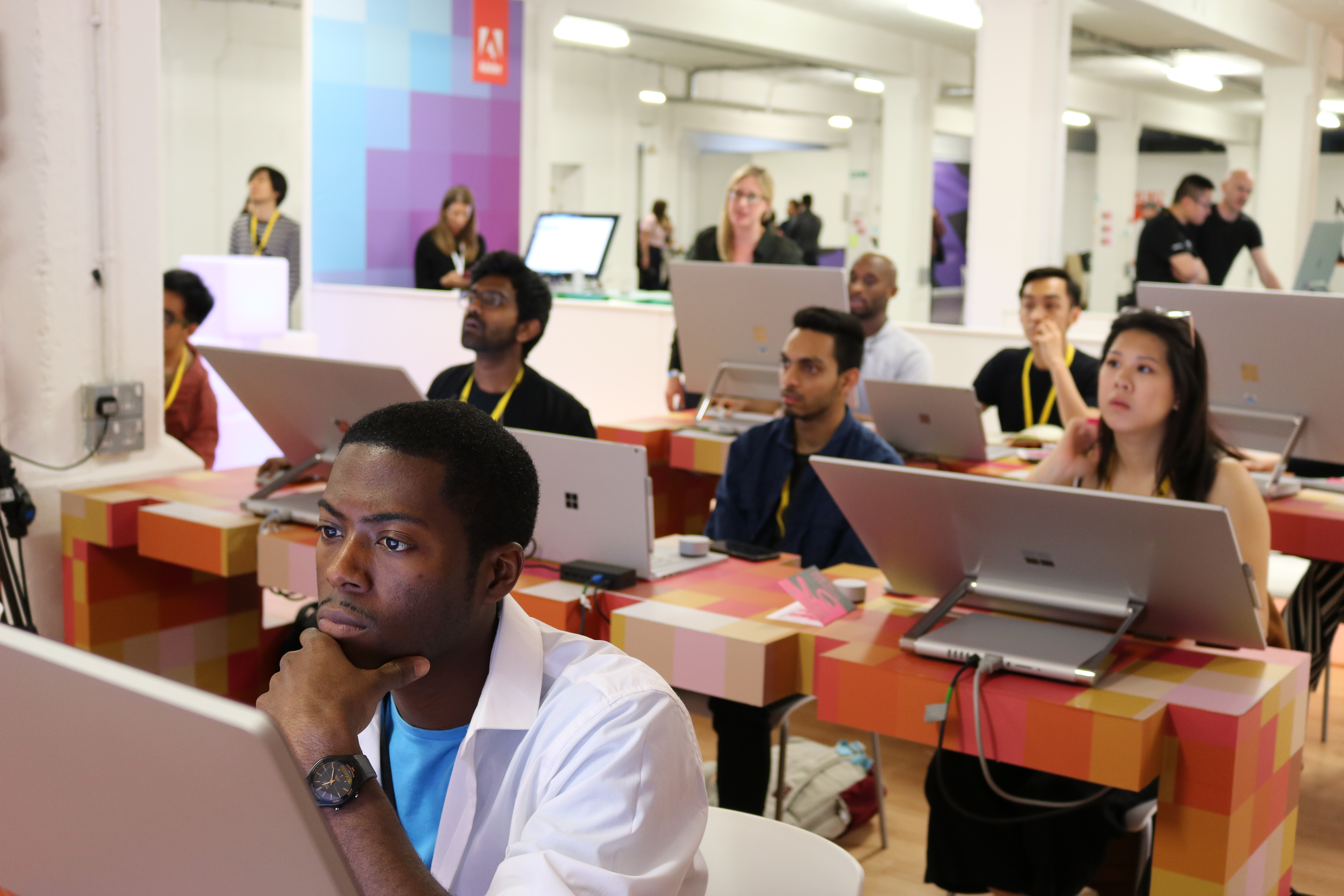 A group of people learn design techniques on Surface devices at D&AD
