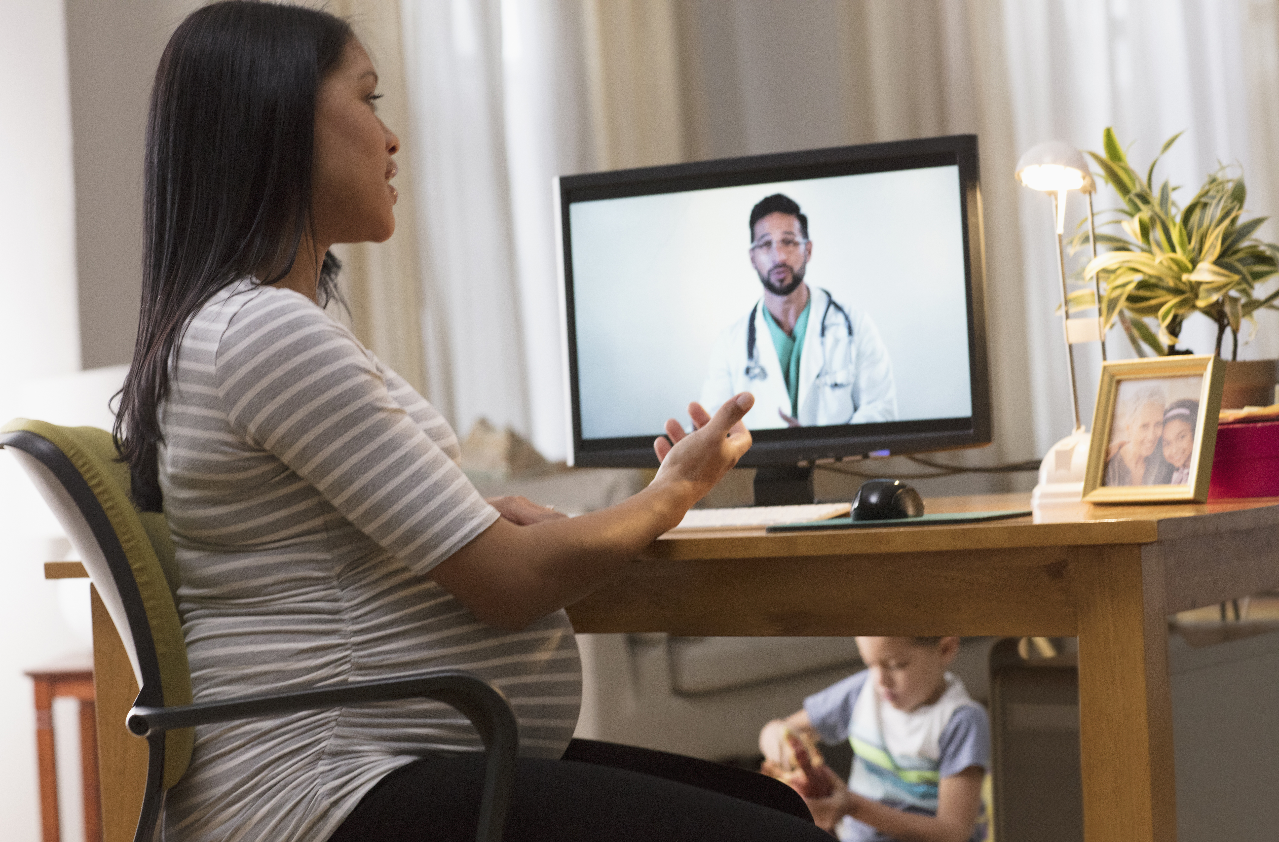 Pregnant woman having a video call with her doctor