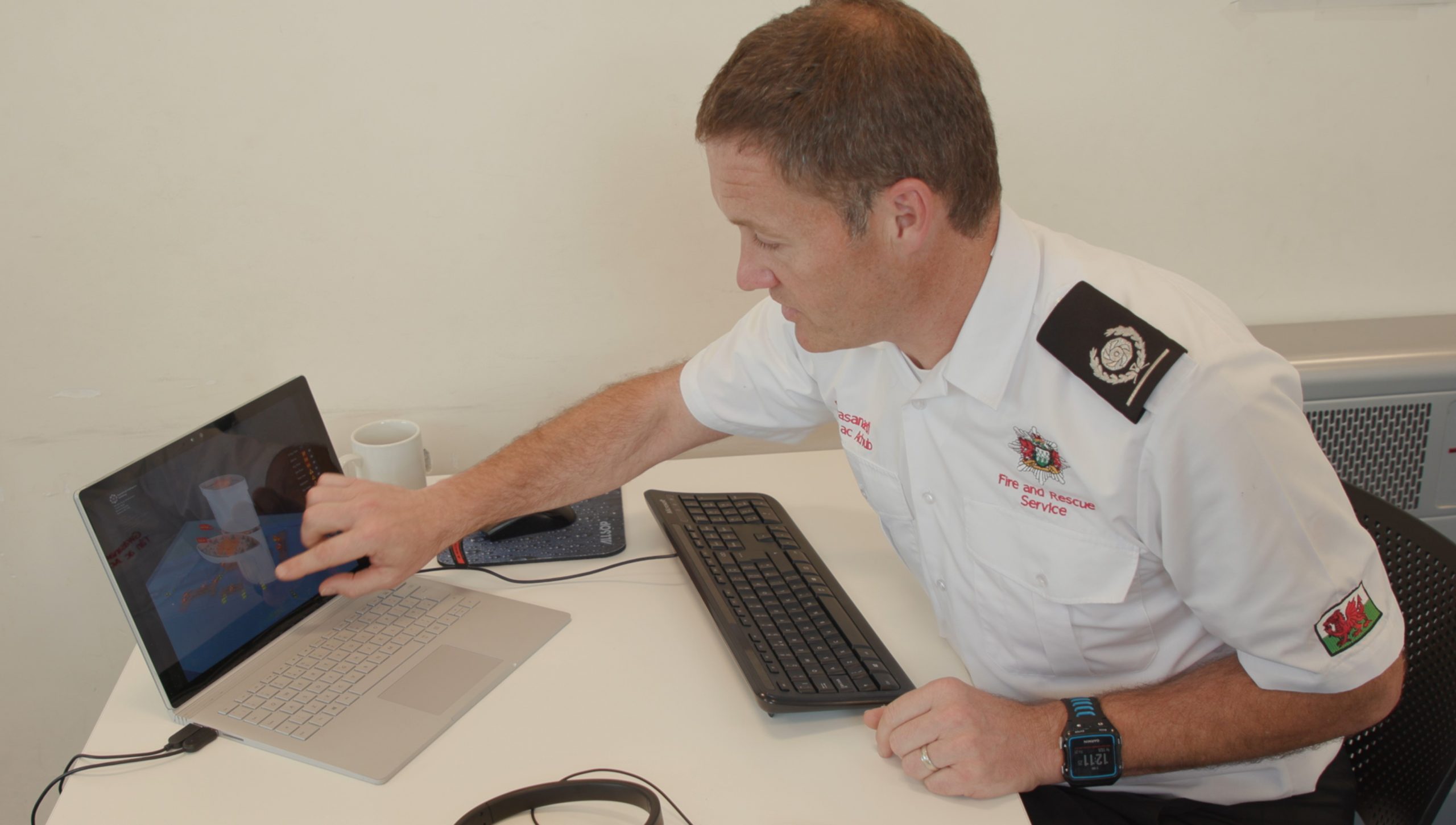 A fire officer uses a Surface Book at Mid and West Wales Fire and Rescue Service