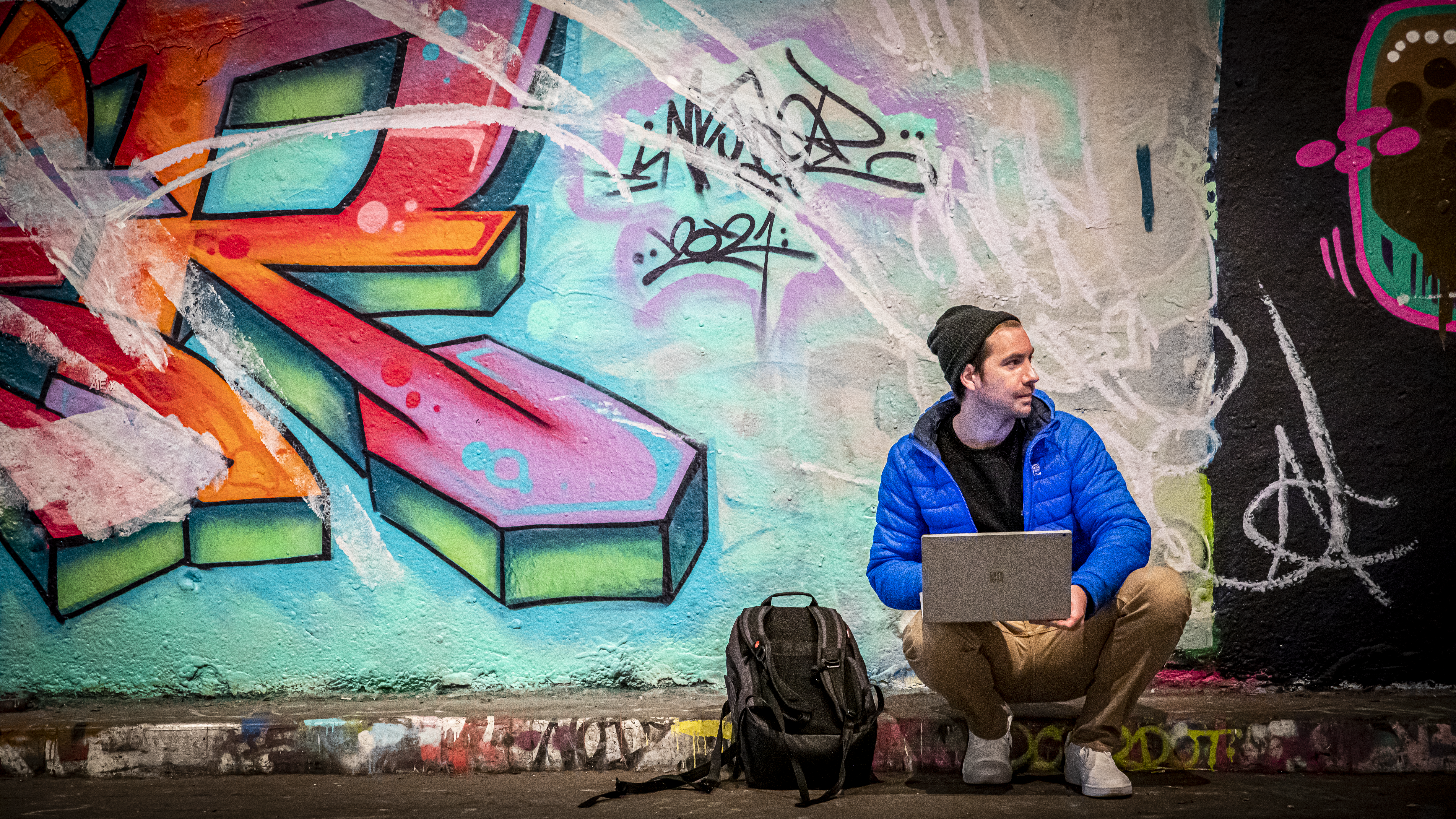 Artist Paperboyo sits on a London street and uses a Surface device