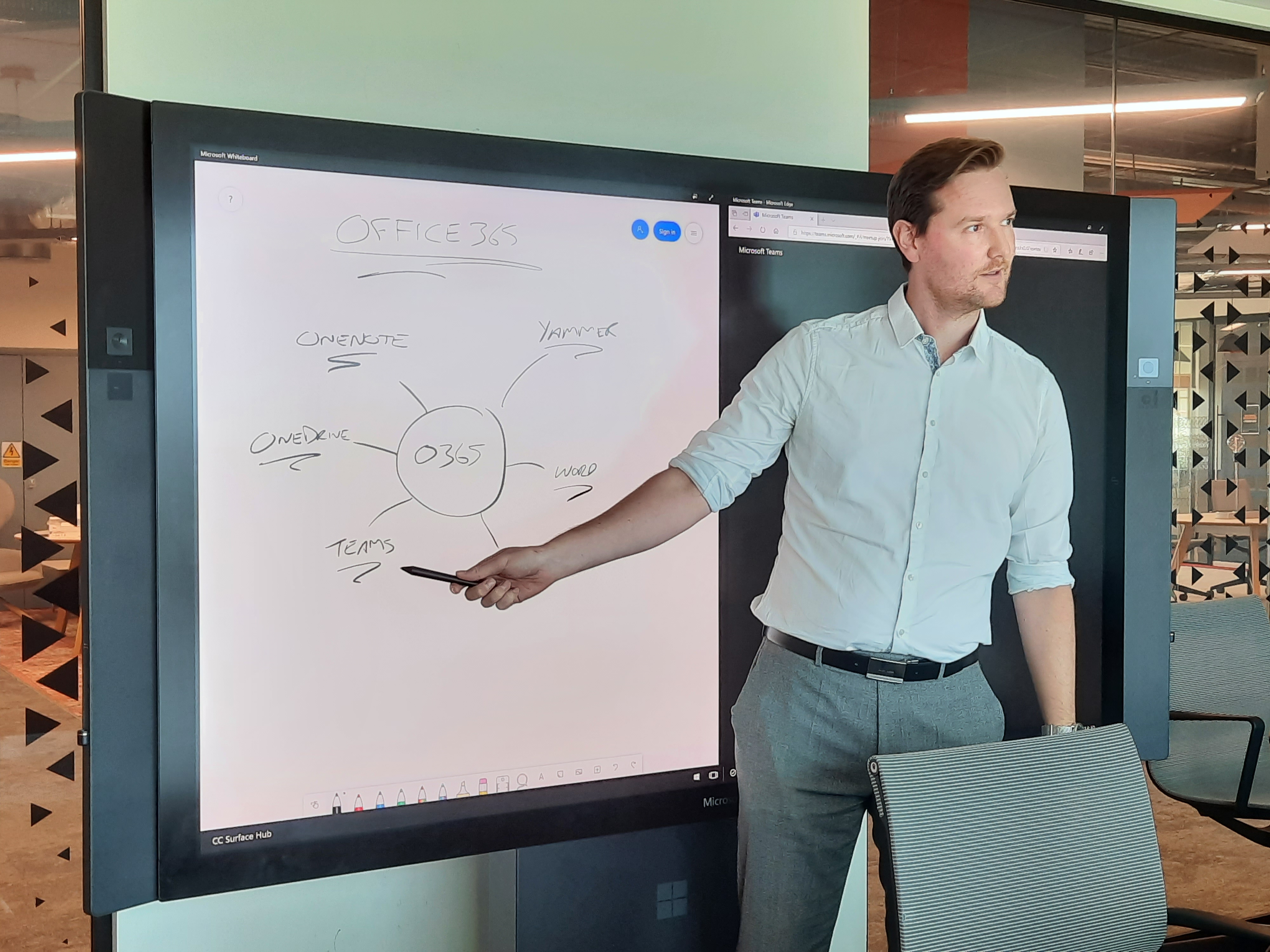 A man points to a Surface Hub