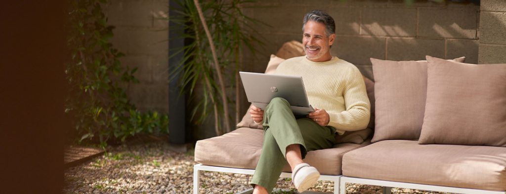 A person sitting on a chair with a laptop