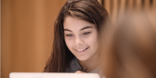 Girl smiling at laptop screen
