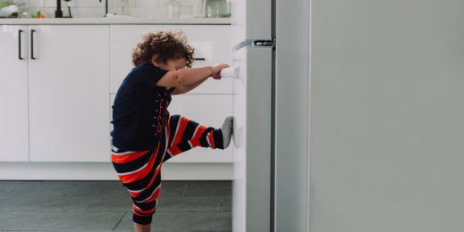 child opening a fridge door