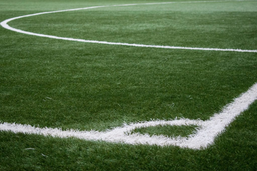 soccer pitch corner, white lines painted on green grass