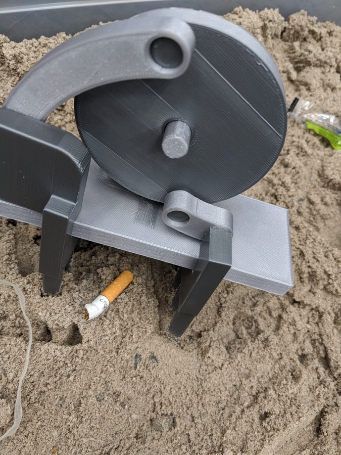 BeachBot's grippers are about to collect a cigarette butt from the sand. 
