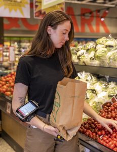 Grocery store worker using smart technology solutions