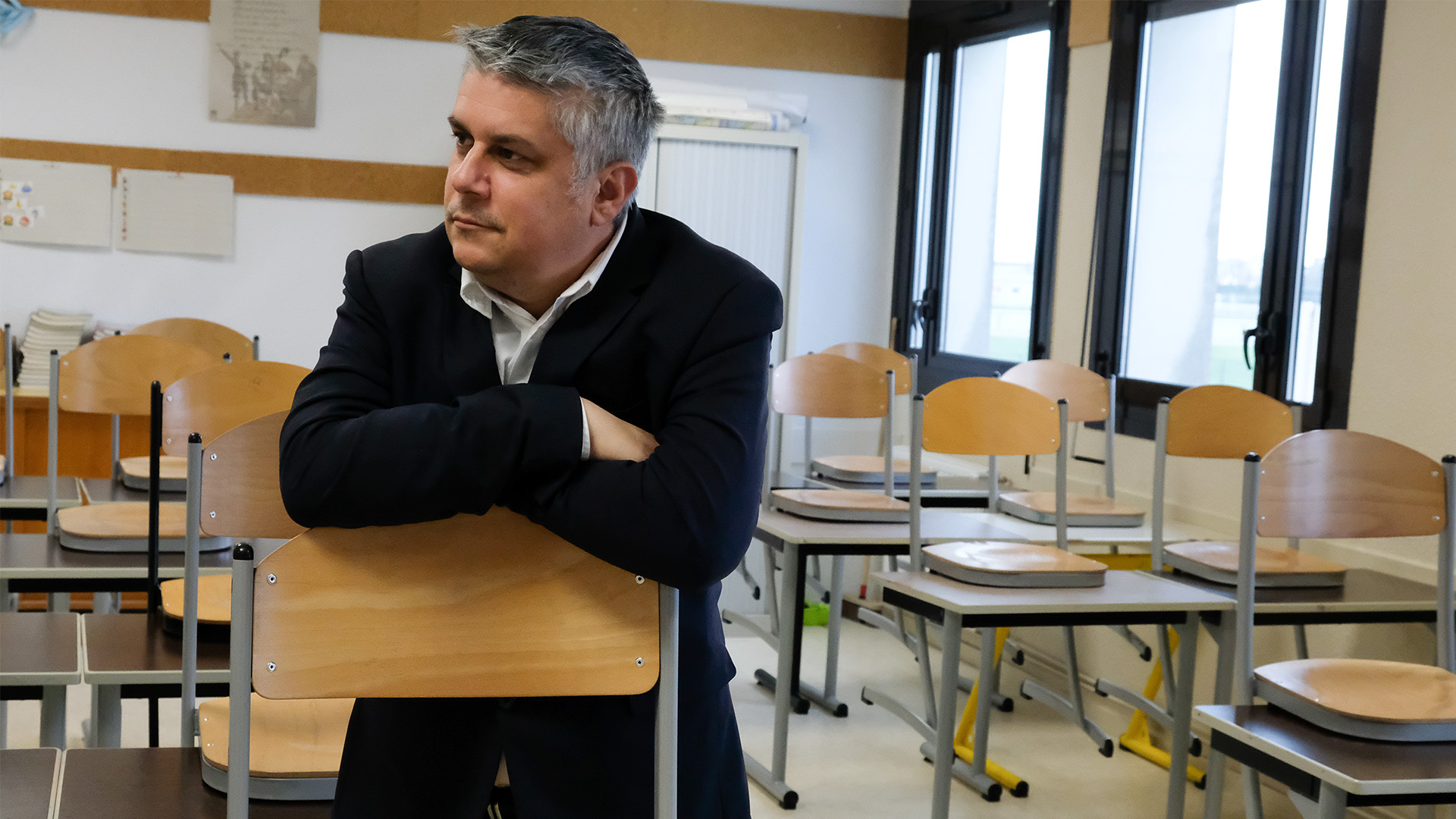 Man in a classroom at a French middle school that has smart building technology.