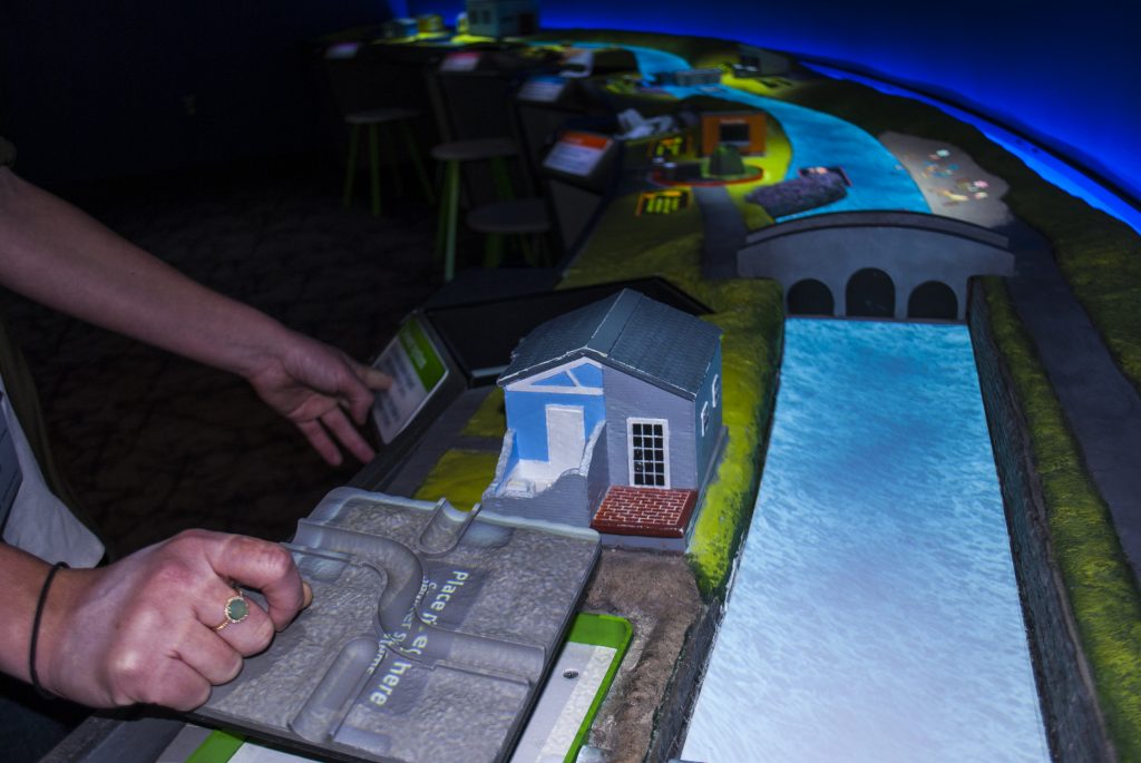 Boston’s Museum of Science relies on table-top screens and projectors for this interactive “Engineering in a River System” exhibit. (Photo by Malorie Landgreen, Museum of Science.)