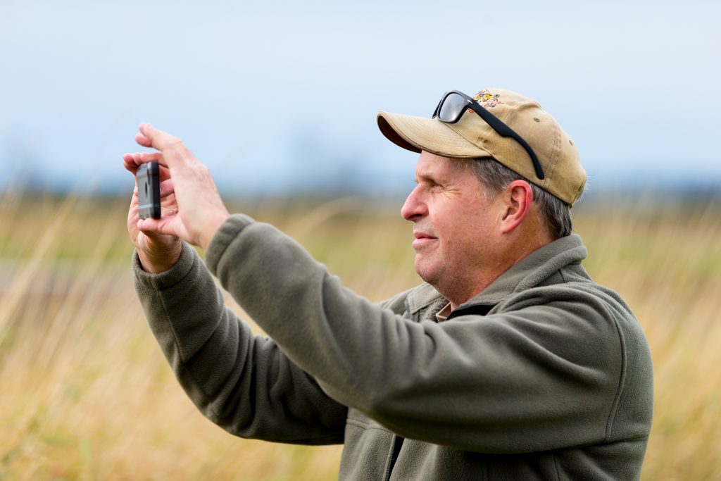 Chuck Mell downloaded the uReporter app onto his smart phone to submit his pictures to the Skagit Valley Herald. (Photo by Scott Eklund/Red Box Pictures)
