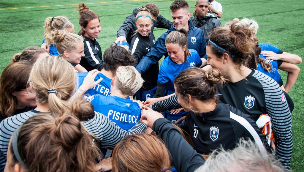Seattle Reign teammates huddle during a game against the Portland Thorns FC. (Image courtesy of the Seattle Reign) 