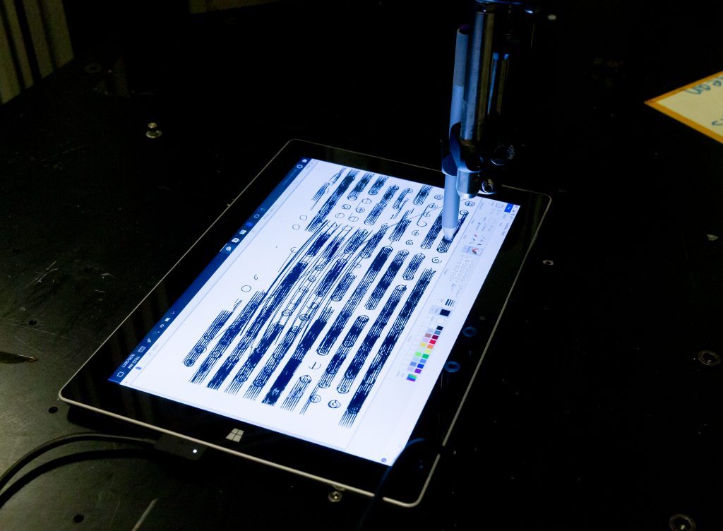 A Surface Pen, guided by a robotic arm, spends weeks drawing lines, symbols and shapes on Surface screen.