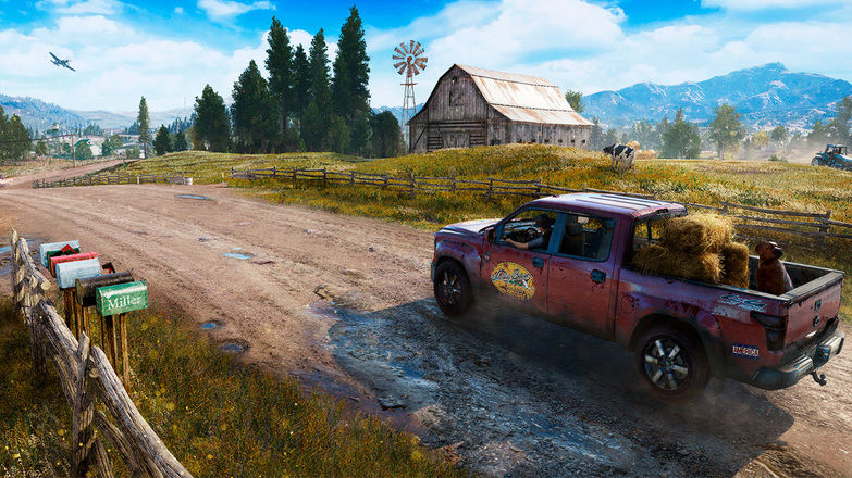 Far Cry 5. A pickup truck drives down a dirt road in Hope County, Montana, with an old barn and fields in the background